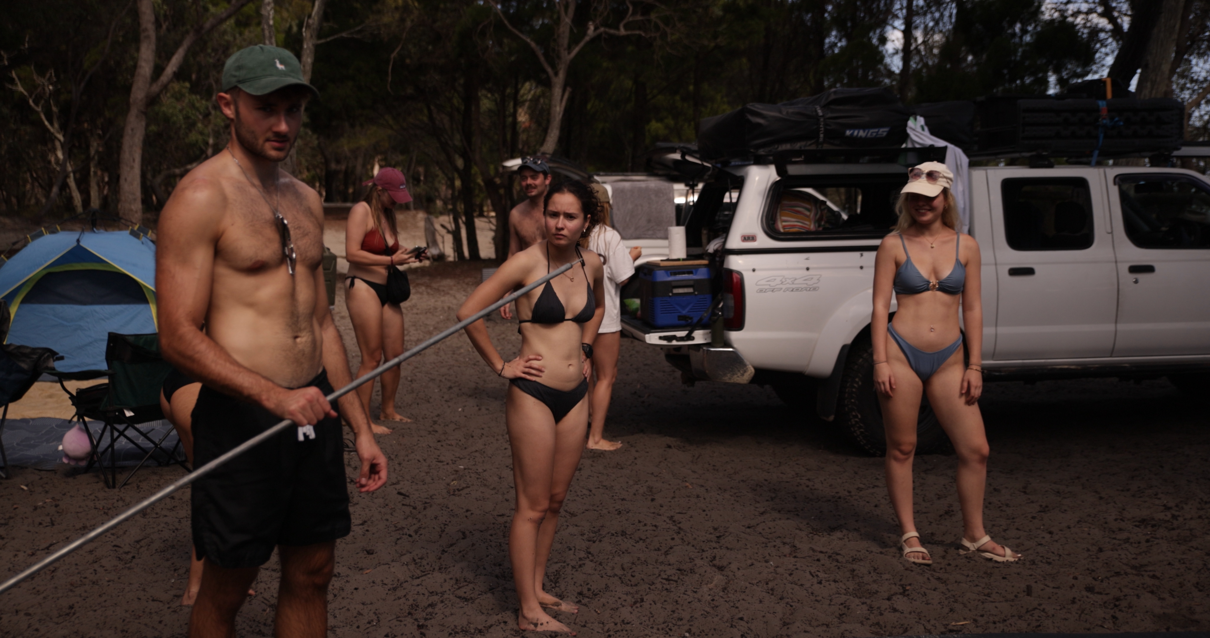 Two smiling friends leaning on a 4WD during an island tour